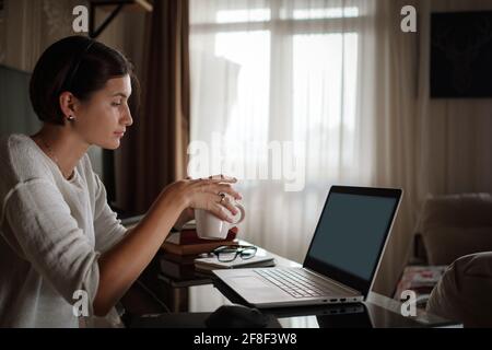 Lächelnd junge asiatische Frau Video anrufen auf Laptop. Rückansicht Foto Student Blick auf Computer-Bildschirm beobachten Webinar oder tun Video-Chat mit Webcam. Stockfoto