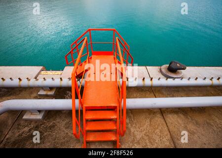 Nahaufnahme des Ölladerminals für Öltankschiffe. Orangefarbene Treppen und Geländer. Seehafen Bautino. Kaspisches Meer, Kasachstan Stockfoto