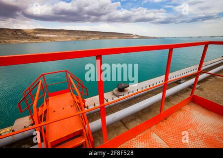 Nahaufnahme des Ölladerminals für Öltankschiffe. Orangefarbene Treppen und Geländer. Seehafen Bautino. Kaspisches Meer, Kasachstan Stockfoto