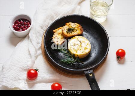 Lecker schön gebackenen Camembert mit Honig, Walnüssen, Kräutern und Preiselbeeren. Stockfoto