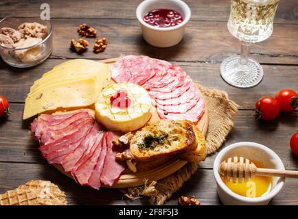 Antipasto Platte kaltes Fleisch mit Brot, Salami, Scheiben Schinken und Käse auf einem hölzernen Hintergrund Stockfoto