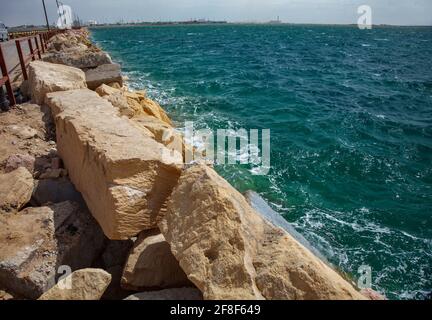 Felsen und Straße am Pier zum Verladeterminal für Flüssiggas. Küstenlinie des Kaspischen Meeres, Kasachstan. Stockfoto