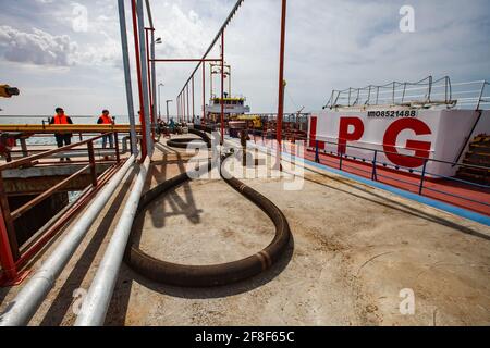 Aktau, Kasachstan - Mai 19 2012: LPG-Tankschiff 'Anbutane' für den Transport von Flüssiggas. Kaspisches Meer, Gas-Ladeterminal. Gasschlauch am Pier. Stockfoto