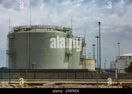 Aktau, Kasachstan - Mai 19 2012: Öllagerterminal am Kaspischen Meer. Frachthafen Aktau. Riesige Tanks der KaztranOil-Gesellschaft und Masten am blauen Himmel. Stockfoto