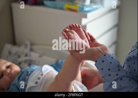 Mutter, die Windeln von niedlichen kleinen Jungen wechselt Stockfoto