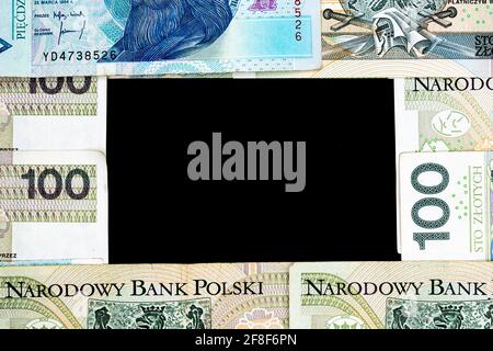Polnische Banknoten von 100 PLN und 50 PLN auf schwarzem Hintergrund. Foto aufgenommen unter weichem Kunstlicht Stockfoto