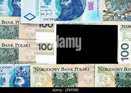 Polnische Banknoten von 100 PLN und 50 PLN auf schwarzem Hintergrund. Foto aufgenommen unter weichem Kunstlicht Stockfoto