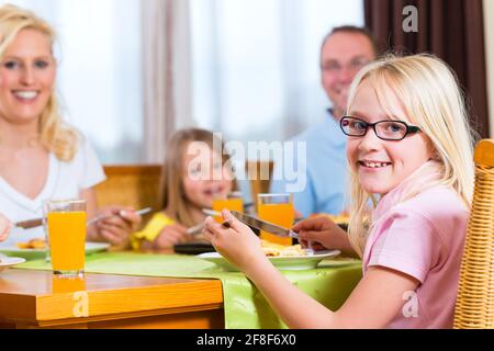 Familie Mittag- oder Abendessen zu essen und am Tisch sitzen Stockfoto