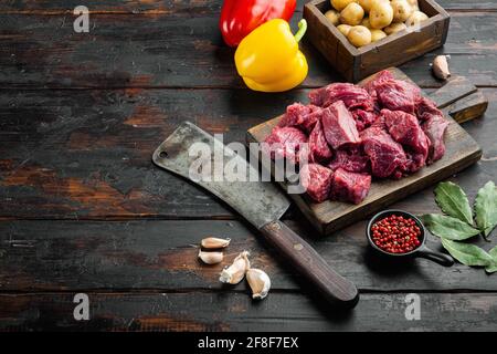 Rohes Kalbfleisch zum Eintopf mit süßem Paprika, auf altem dunklen Holztisch, mit Platz für Text Stockfoto