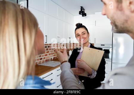 Rückansicht eines Paares, das mit dem Immobilienmakler sprach Stockfoto