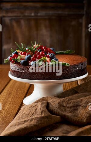 Schokoladenkuchen aus Schokoladenpfannkuchen mit Sahnehäubchen, mit Heidelbeeren. Kopierbereich, selektiver Fokus Stockfoto