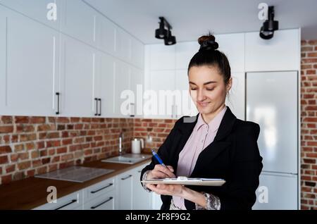 Immobilienmakler füllt Dokumente in einer neuen Wohnung aus Stockfoto