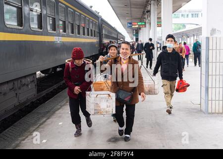 (210414) -- CHANGSHA, 14. April 2021 (Xinhua) -- Passagiere steigen in den Zug 7265 ein, nachdem sie ihre Waren am Bahnhof Jishou in der zentralchinesischen Provinz Hunan verkauft hatten, 11. April 2021. Die 7265/7266/7267-Züge wurden 1995 in Betrieb genommen und erstrecken sich über mehr als 300 Kilometer vom Bahnhof Huaihua zum Bahnhof Lixian. Die Züge fahren in 9 Stunden und 16 Minuten an 37 Haltestellen vorbei. Die Ticketpreise reichen von 1 Yuan bis 23.5 Yuan (etwa 0.15-3.59 US-Dollar), die seit 26 Jahren nicht mehr angehoben wurden. Die Züge fahren durch die Wuling Mountains. Dank ihnen können Dorfbewohner nicht nur Frui tragen Stockfoto