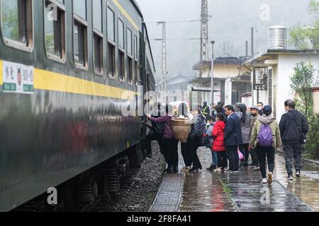 (210414) -- CHANGSHA, 14. April 2021 (Xinhua) -- Passagiere besteigen den Zug 7266 am Bahnhof Dalongcun in der zentralchinesischen Provinz Hunan, 11. April 2021. Die 7265/7266/7267-Züge wurden 1995 in Betrieb genommen und erstrecken sich über mehr als 300 Kilometer vom Bahnhof Huaihua zum Bahnhof Lixian. Die Züge fahren in 9 Stunden und 16 Minuten an 37 Haltestellen vorbei. Die Ticketpreise reichen von 1 Yuan bis 23.5 Yuan (etwa 0.15-3.59 US-Dollar), die seit 26 Jahren nicht mehr angehoben wurden. Die Züge fahren durch die Wuling Mountains. Dank ihnen können die Dorfbewohner nicht nur Obst, Gemüse und andere Loka mitnehmen Stockfoto