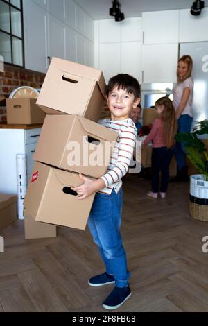 Porträt eines glücklichen Jungen, der eine Pappschachtel hält Stockfoto