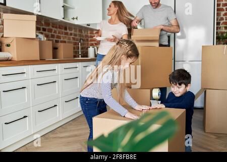 Geschwister helfen beim Verpacken von Pappkartons für den Umzug Stockfoto