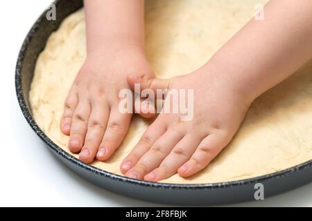Kleiner Junge, der Pizza oder Brotteig knetet Stockfoto