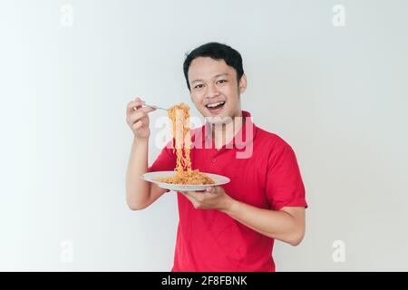 Porträt von glücklich junger asiatischer Mann genießt Nudeln. Essen Mittagessen Konzept. Stockfoto