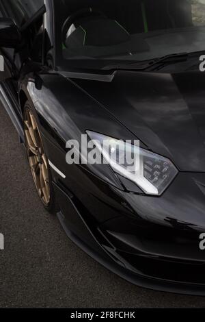 Eine schwarze 2020 Lamborghini Aventador SVJ Frontblende mit Goldene Leichtmetallräder und LED-Scheinwerfer mit Aerodynamik vorne Stockfoto