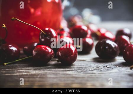 Reife und saftige Kirschen auf dem dunklen rustikalen Hintergrund. Selektiver Fokus. Geringe Schärfentiefe. Stockfoto