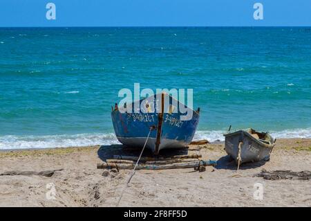 Zwei alte hölzerne Ruderboote unterschiedlicher Größe am Sandstrand des Schwarzen Meeres an einem klaren, blauen Himmel, sonnigen Sommertag Stockfoto