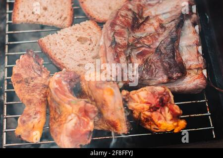 Köstliches Fleisch auf Grill mit Dampf.Close Up.Huhn, Rindfleisch und Brot Stockfoto