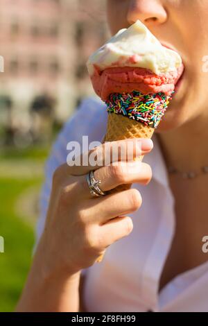 Junge Frau isst Eis in einem park Stockfoto