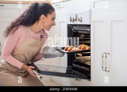 Glückliche Hausfrau. Porträt Einer Lächelnden Millennial-Frau Beim Backen In Der Küche Stockfoto