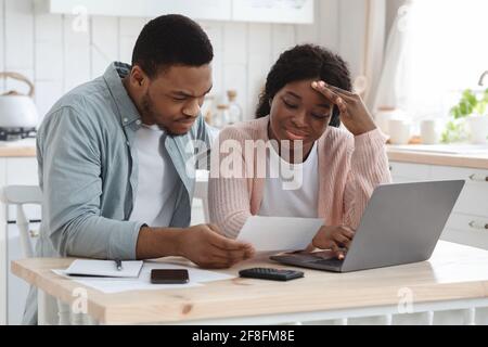 Sorge Schwarze Ehepartner Berechnen Familienbudget In Der Küche, Lesen Von Finanzpapieren Stockfoto