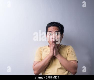 Gesichtsreaktion, asiatischer junger Mann Porträt des Gesichtsausdrucks, schockiert, begeistert, erschrocken, überrascht, Mit bedecktem Gesicht mit der Hand. Isoliert, selektiv Stockfoto