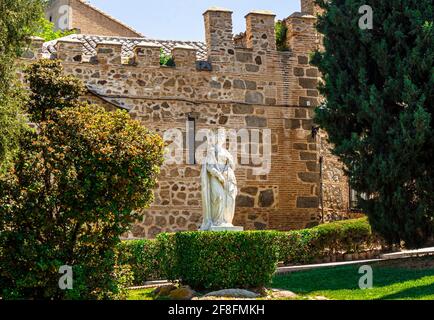 Statue von Isabella I. von Kastilien auf dem Hintergrund der Stadtmauer auf der Plaza de San Juan de los Reyes. Toledo, Castilla La Mancha Spanien. Stockfoto