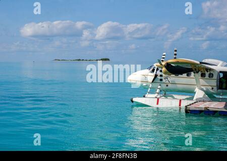 Weißes Wasserflugzeug auf der türkisfarbenen maledivischen Lagune. Luxuriöses Reisekonzept Stockfoto