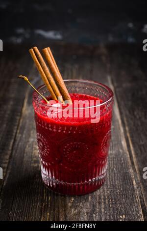 Kirschsmoothie mit Zimt in altmodischem Glas auf rustikalem Holzhintergrund. Selektiver Fokus. Geringe Schärfentiefe. Stockfoto