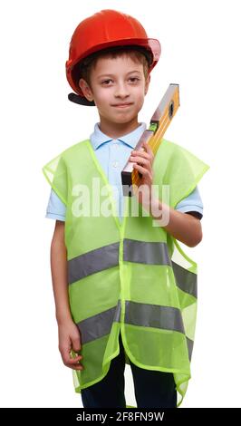 Niedlicher lächelnder Junge in Schutzhelm und Bauweste mit Messpegel auf weißem isoliertem Hintergrund. Zukünftiger Bauingenieur. Stockfoto