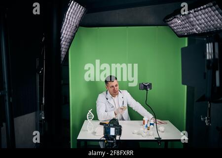 Hübscher männlicher Arzt, der Video für einen medizinischen Blog aufzeichnet Stockfoto