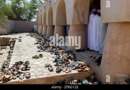 Viele Schuhe neben dem Gebetsraum der Jami Al Hamoda Moschee in der Stadt Jalan Bani Ben Ali. Ash Sharqiyah South Governorate. Oman Stockfoto