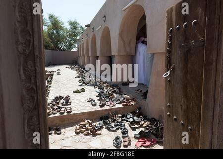 Viele Schuhe neben dem Gebetsraum der Jami Al Hamoda Moschee in der Stadt Jalan Bani Ben Ali. Ash Sharqiyah South Governorate. Oman Stockfoto