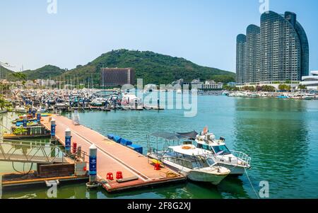 Sanya China , 24. März 2021 : Panorama der Marina und Sanya Fluss mit Booten und Stadtgebäuden in Sanya Stadt Hainan China Stockfoto