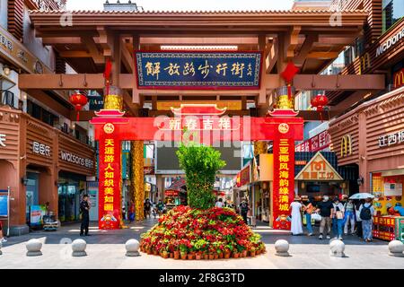 Sanya China , 24. März 2021 : Eingangstor und Menschen an der Jiefang Straße Fußgängerzone Einkaufsstraße in Sanya Hainan China Stockfoto