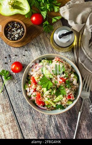 Essen Diät-Konzept, Thunfisch-Salat. Couscous-Salat mit konservierten Thunfisch, Tomaten, Gurken und lila Zwiebeln auf rustikalem Holztisch. Speicherplatz kopieren. Stockfoto