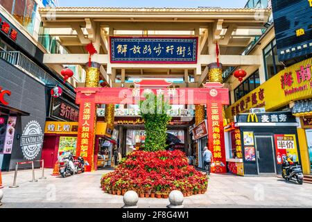 Sanya China , 24. März 2021 : Eingang Torbogen und Blick Jiefang oder kurze Straße Fußgängerzone Einkaufsstraße in Sanya Hainan China Stockfoto
