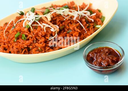 Schezwan gebratener Reis mit schezwan-Sauce, chinesischer gebratener Reis, garniert mit Frühlingszwiebeln und Kohl indo chinesische Küche Gerichte Stockfoto