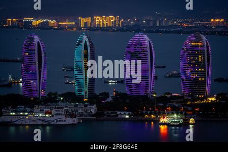 Sanya China , 24. März 2021 : Phoenix Island Ocean Dream Resort Gebäude in blau und lila nachts beleuchtet Panoramablick in Sanya Bucht Hainan isla Stockfoto