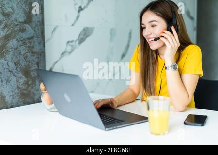 Freiberuflicher Mitarbeiter, der mit Headsets spricht und Kunden vom Heimbüro aus berät. Stockfoto