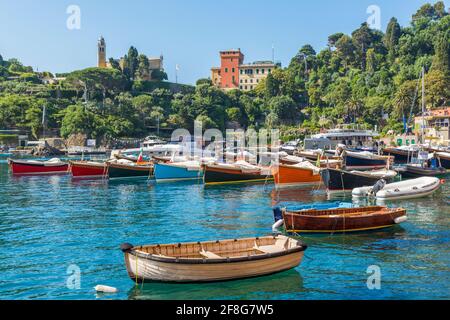 Portofino, Provinz Genua, Ligurien, italienische Riviera, Italien.  Boote im Hafen mit dem Dorf hinter. Stockfoto