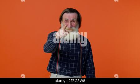 Älterer amüsant Mann, der mit dem Finger auf die Kamera zeigt, laut lachend vor lächerlicher Erscheinung, witziger Witz Stockfoto