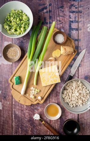 Flache Zutatenlage für vegane Wontonknödel mit Tofu und Brokkoli, Rezept für Wontonsuppe, vertikal Stockfoto