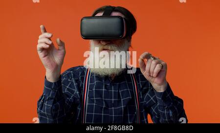 Stilvoller grauhaariger Mann mit Headset-Helm-App zum Spielen Simulation Virtual Reality VR-Spiel Stockfoto