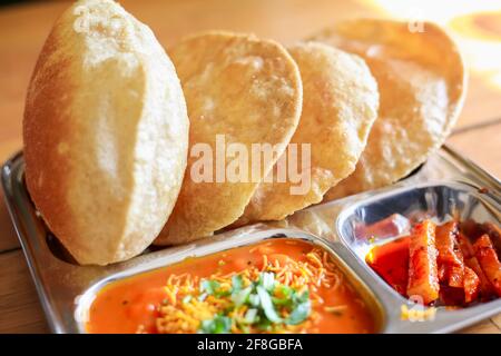 Puri Sabji oder Poori Sabzi. Indischer Snack. Indisches gebratenes Brot serviert mit würzigem Gemüsepfarsich und würzigen Gurken. Köstlich aussehendes indisches Essen. Diese t Stockfoto