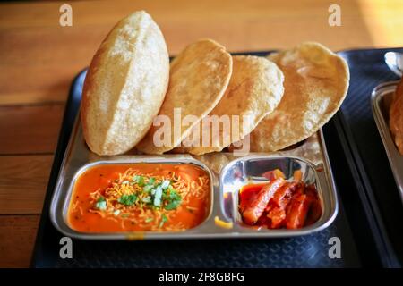 Puri Sabji oder Poori Sabzi. Indischer Snack. Indisches gebratenes Brot serviert mit würzigem Gemüsepfarsich und würzigen Gurken. Köstlich aussehendes indisches Essen. Diese t Stockfoto